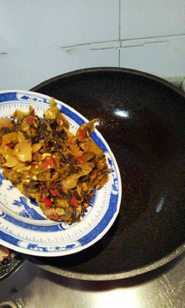 酸菜鱼,锅里倒植物油加入佐料包里的酸菜煸炒出香味
