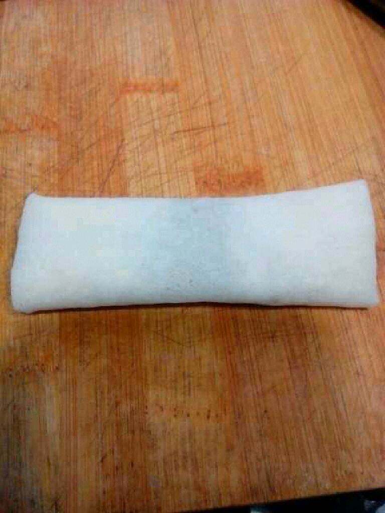 炸春卷,卷好了用一点水把边粘好。