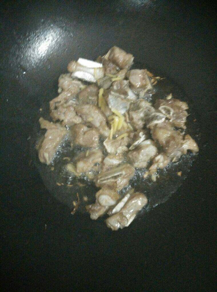 土豆排骨焖饭,锅中热油，小火放排骨煎，煎至两面金黄放姜丝略炒几下