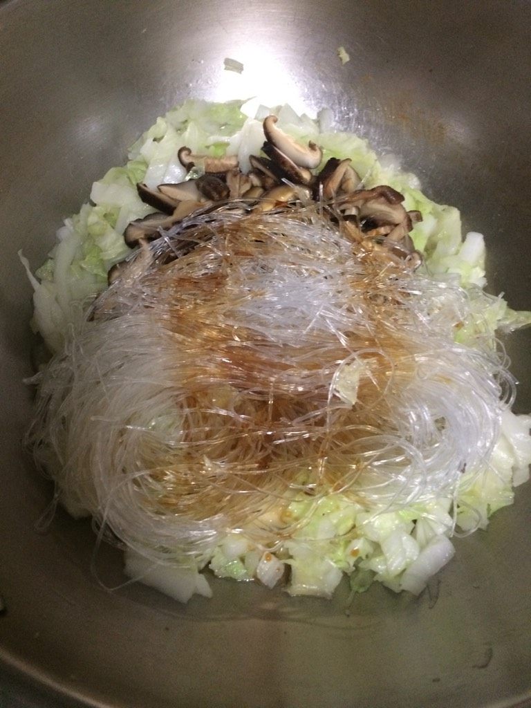 三十而栗(香菇丝、粉丝、白菜丝),如图至白菜变软,加入香菇丝、粉丝,加少许生抽,翻炒均匀后加少许水焖煮8-10分钟;