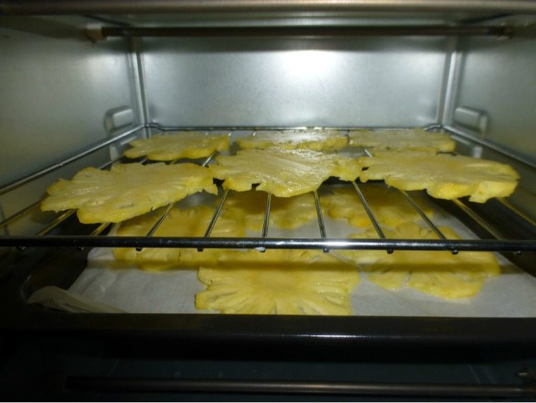 菠萝花干,将菠萝切成薄片，越薄越好，先铺平放在烤网中，烤箱先用80度烤30分钟，一直到菠萝软软的