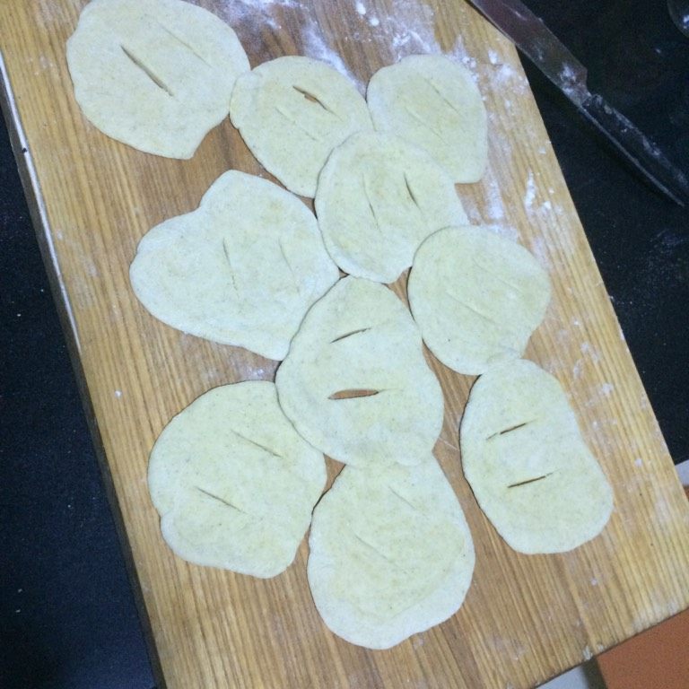回族点心【油香】,如图揉匀,切成大小均匀的面剂子,擀成厚薄均匀的薄片,在面片中间划两刀