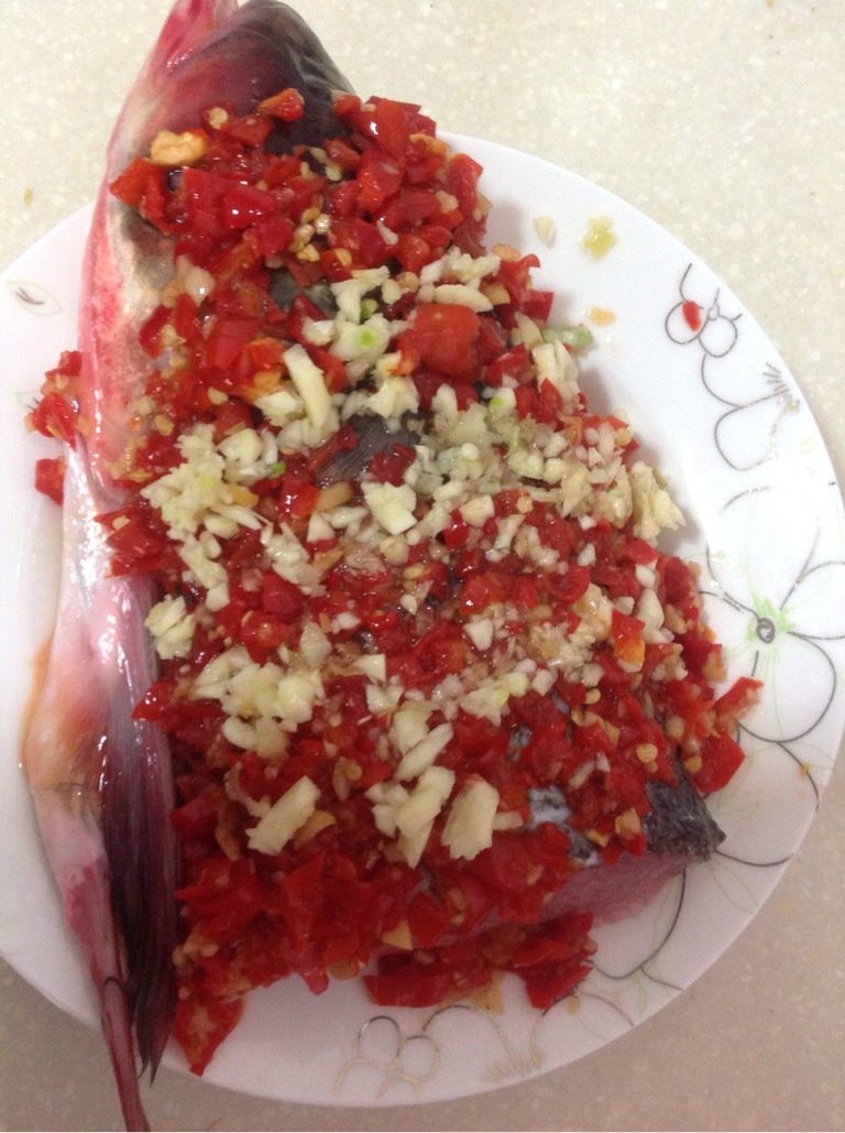 剁椒鱼头,如图鱼头上铺满<a style='color:red;display:inline-block;' href='/shicai/ 803'>剁椒</a>，蒜泥，加适量料酒，入锅大火蒸十五分钟
