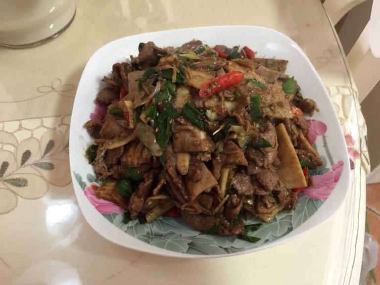 冬笋炒牛肉,用锅中剩下的油煸炒辣椒、青蒜,倒入冬笋一同煸炒,加少许盐让冬笋上味