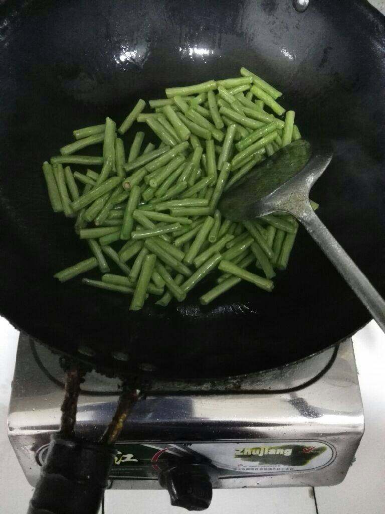 干煸豆角,锅里热油倒入豆角翻炒，一直炒到豆角起皮盛起来，把油留锅里