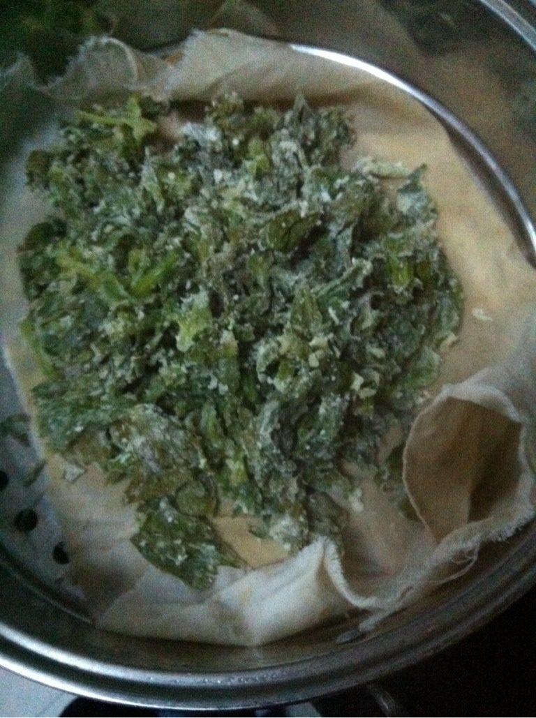 蒸芹菜叶,把抓匀的菜叶放入蒸锅蒸三分钟,取出