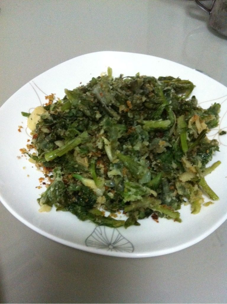 蒸芹菜叶,炒锅加油,下葱蒜炒香,加入芹菜叶,翻炒至菜叶上的面粉微黄,加盐,出锅