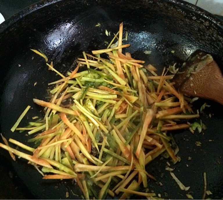 炒三"思"(丝),如图,用猪油先爆炒胡萝卜约2分钟,再入笋丝炒约1分钟,加入盐适量,料酒适量翻炒均匀