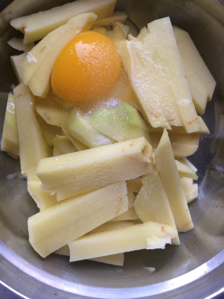 西红柿多面拖土豆条,如图在土豆里打入一个鸡蛋,加少许盐拌匀