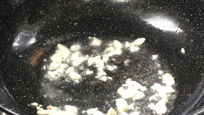 蒜香焖翅,起锅热油,放入蒜末炒香,加盐炒匀