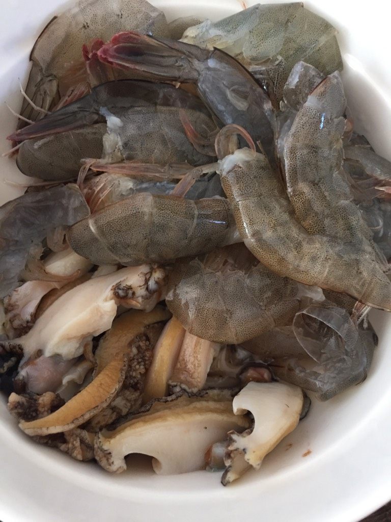 明虾鲍鱼粥,明虾去虾头,对半切。鲍鱼处理干净,切片,一个鲍鱼切四小片。备用