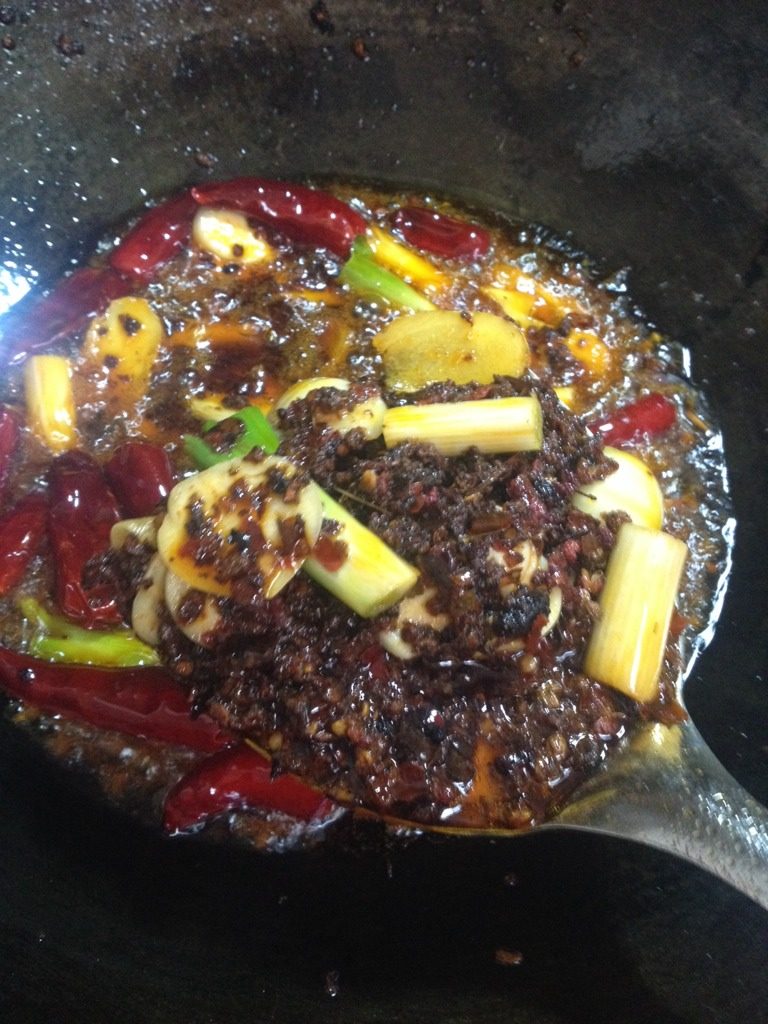 自制四川麻辣火锅,加入葱姜蒜，干辣椒，花椒粒翻炒