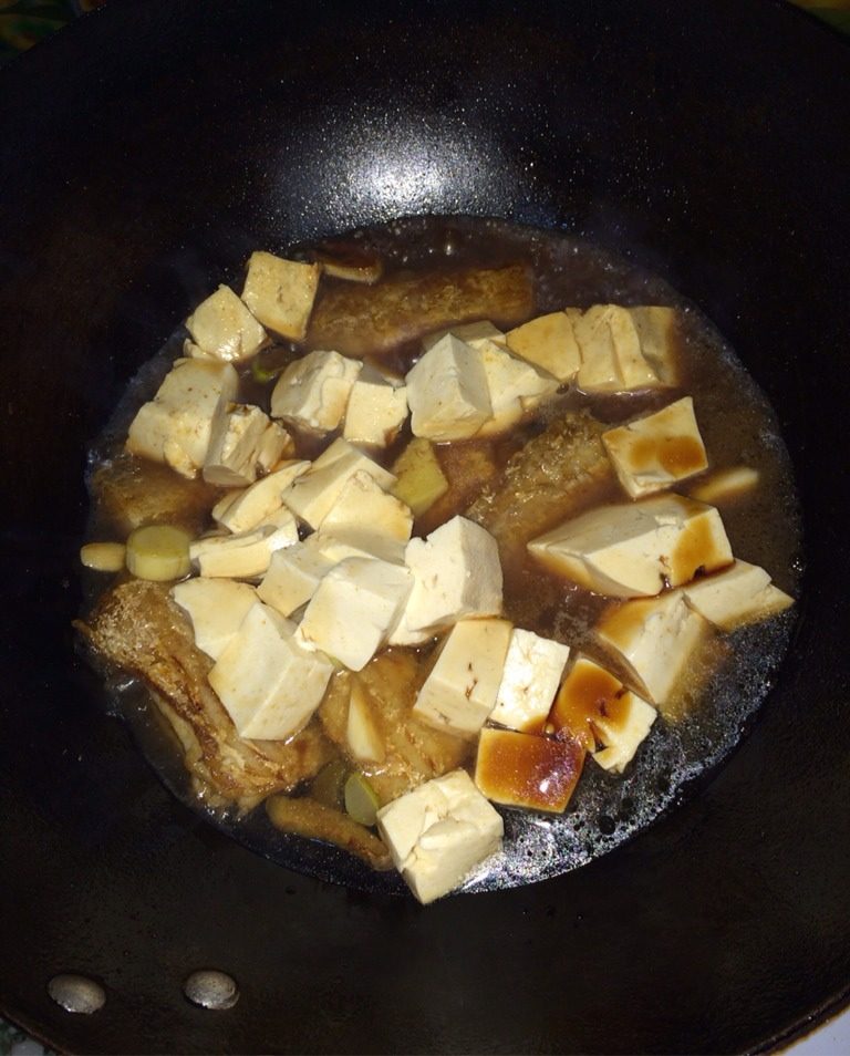 带鱼炖豆腐,喷洒料酒,酱油和陈醋,放入葱姜蒜,翻炒,上色均匀后,添一碗热水,刚刚没过鱼即可
