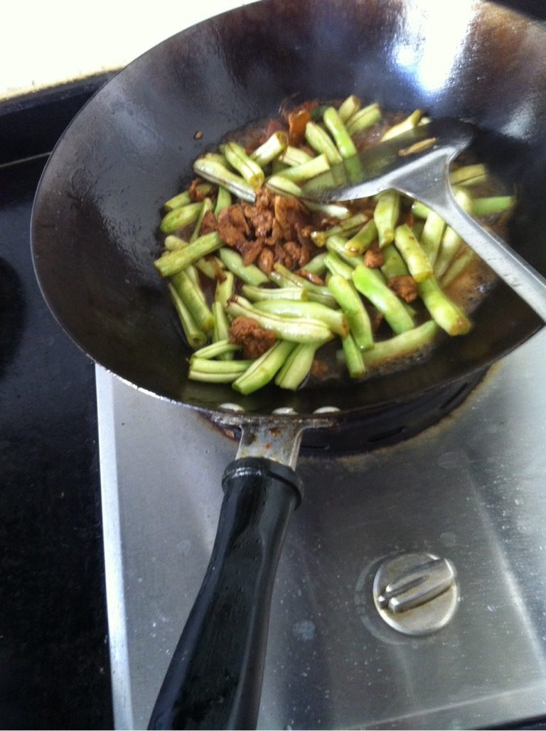 豆角焖面,令取一炒锅至火上，葱姜呛锅，下猪肉翻炒，待肉的颜色变白时加入生抽老抽盐，加水没过豆角，焖几分钟