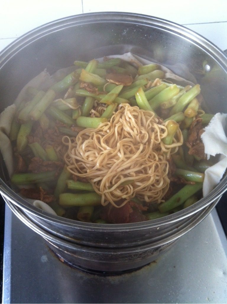 豆角焖面,待豆角变软，关火。把蒸好的面条放入炒锅拌匀，让面把汤汁吸收，然后再把拌匀的面和豆角一起入蒸锅，蒸五分钟即可