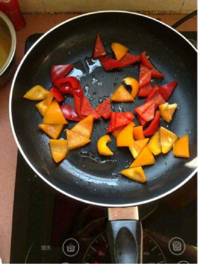 自制【菠萝咕噜肉】,锅里放适量油把红黄辣椒放进去翻炒。