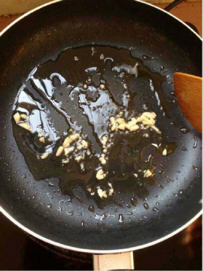 自制【菠萝咕噜肉】,锅里放适量油放入蒜末爆香。