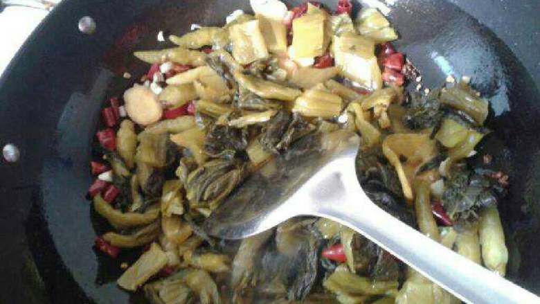 酸菜鱼,倒入小米椒,蒜,姜,最后倒入酸菜翻炒。