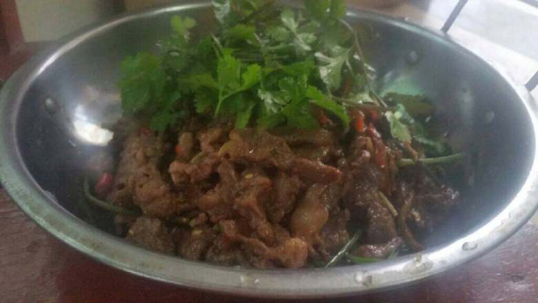 干锅嫩牛肉片,下入香菜梗和香菜根。撒一点<a style='color:red;display:inline-block;' href='/shicai/ 720'>胡椒粉</a>，翻炒，加入少许水，微焖一分钟，收干汤汁，盛入干锅，撒上香菜叶，上火即可食用。