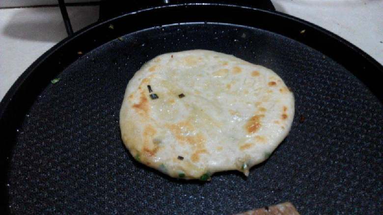 烙葱香饼,煎至两面金黄面饼内有气泡出现时就说明煎好了好了,