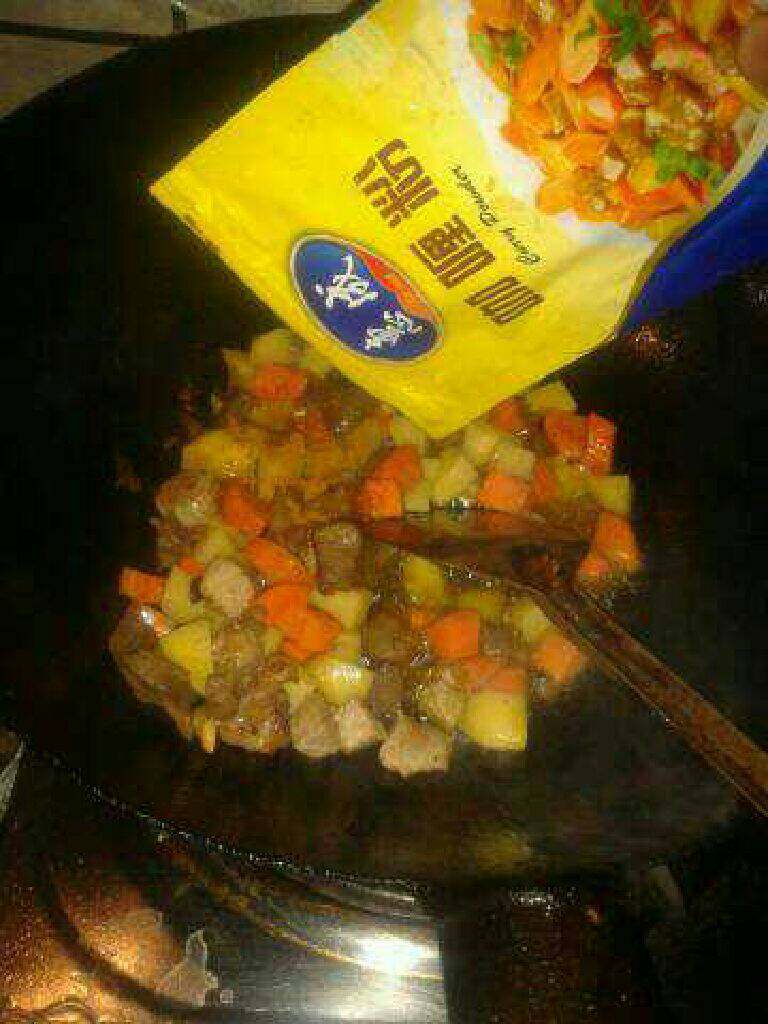 法式咖喱牛肉饭,热锅放油先放葱蒜爆香,倒入腌好的肉,再放入土豆,胡萝卜继续翻炒,接着放咖喱粉,