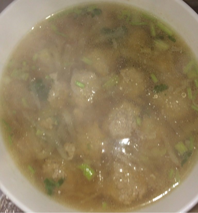 萝卜牛丸汤,开大火,烧开,撇出表面的浮末,加盐,撒葱花香菜末