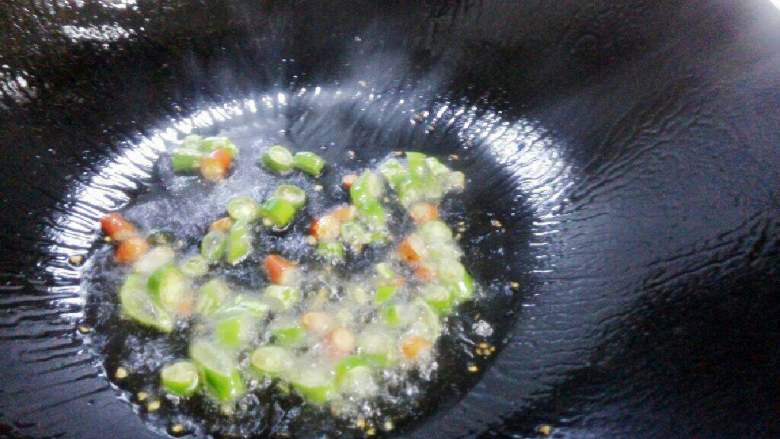 辣白菜豆腐汤,锅底倒少量油,中火加热。倒入青红椒段翻炒几下。