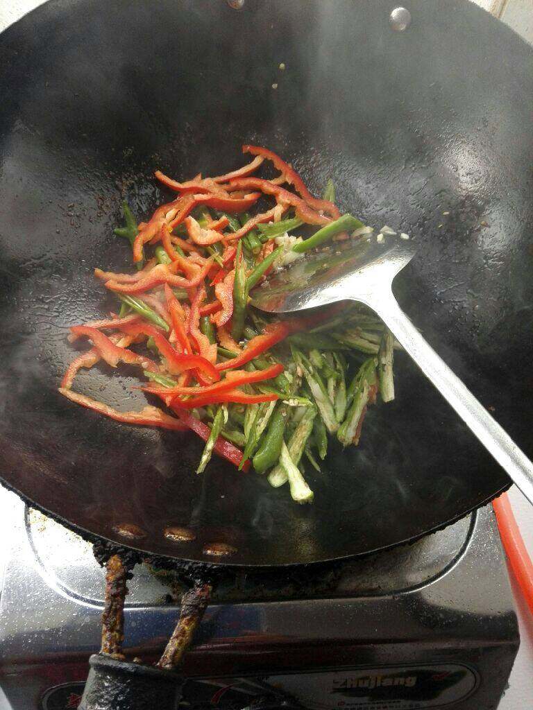 简易版的小炒肉,锅里留油倒入蒜跟青红翻炒,加盐炒匀