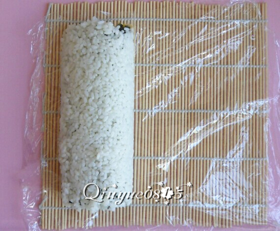 翻转樱花寿司,然后放开寿司帘,把保鲜膜重新铺平。