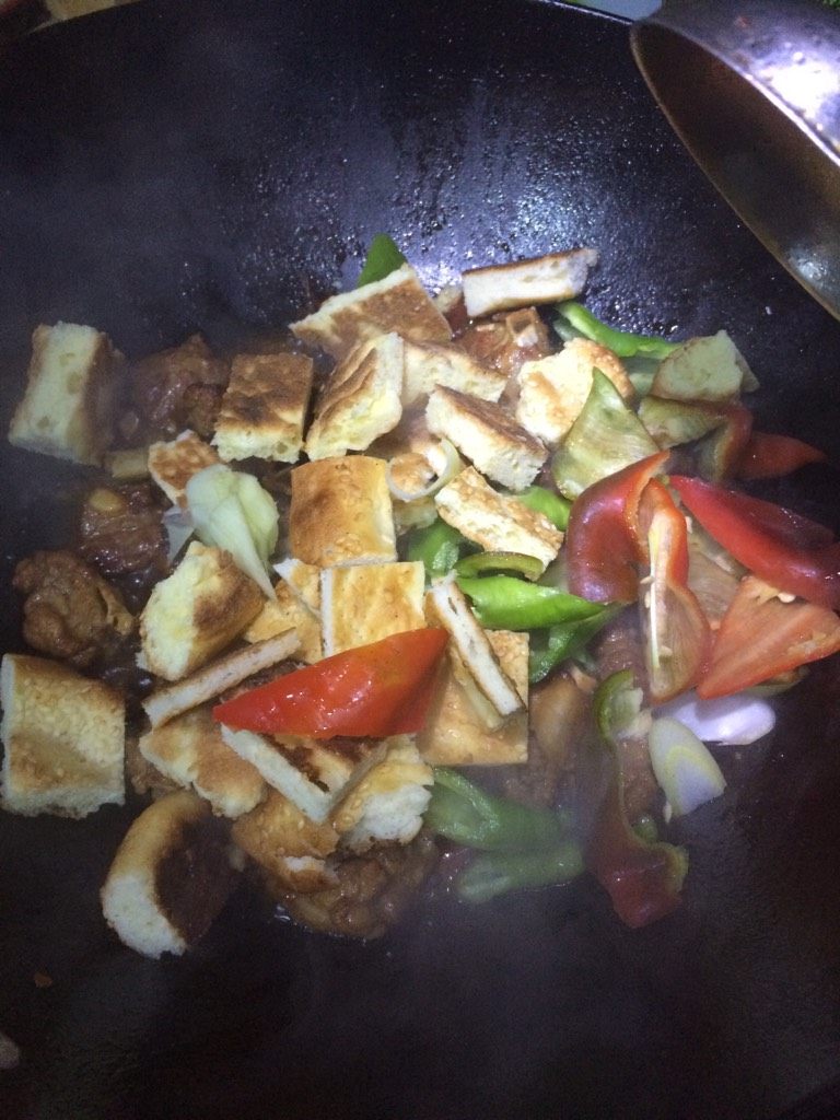 馕包排骨,如图在汤汁不太多,排骨入味后,将切好的馕块和辣椒块下入,快速翻炒至辣椒和葱段炒熟,加少许白糖,翻炒均匀关火