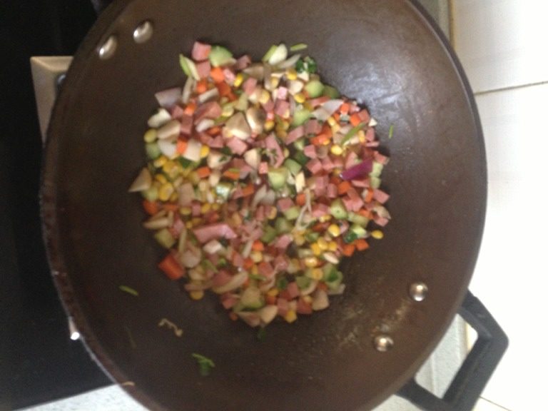 什锦蛋炒饭,锅中倒油,葱花呛锅,放入切好的食材,加入一点盐,生抽,鸡精,如图