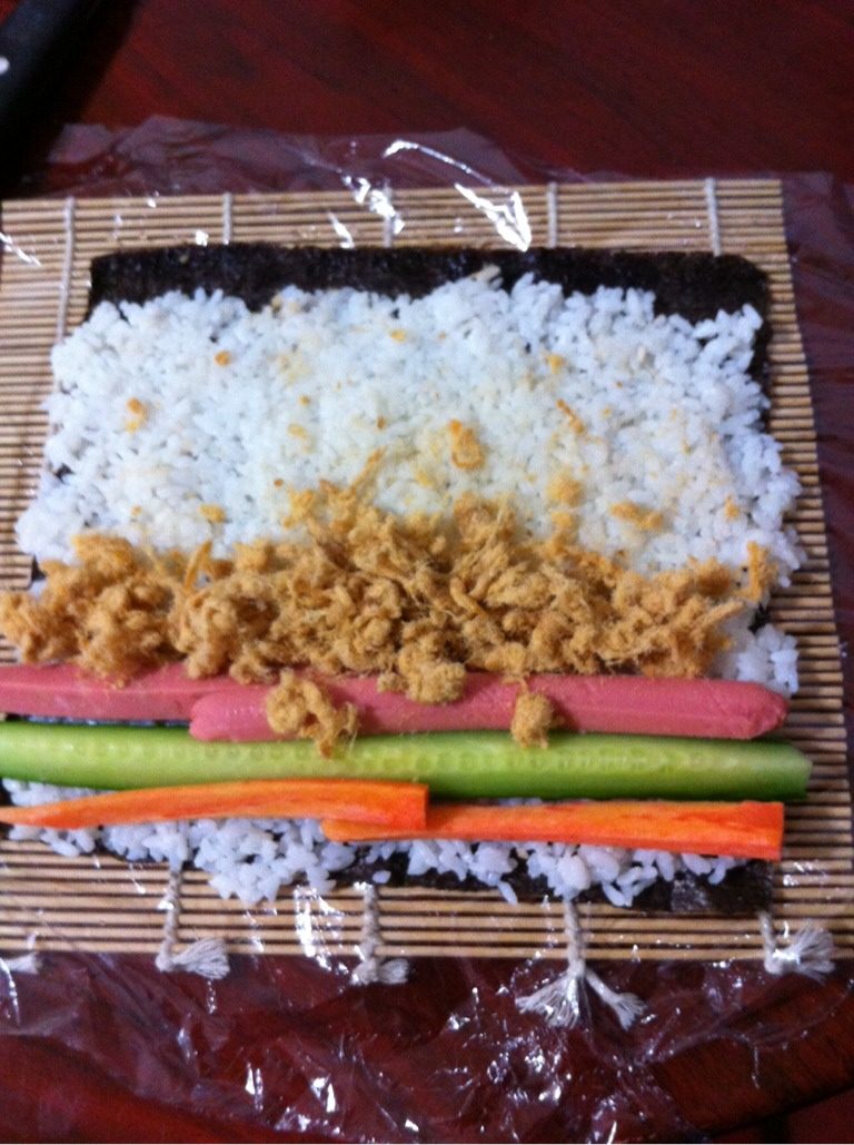 日本菜 寿司,铺上切成条的黄瓜、胡萝卜、火腿肠,再铺上肉松