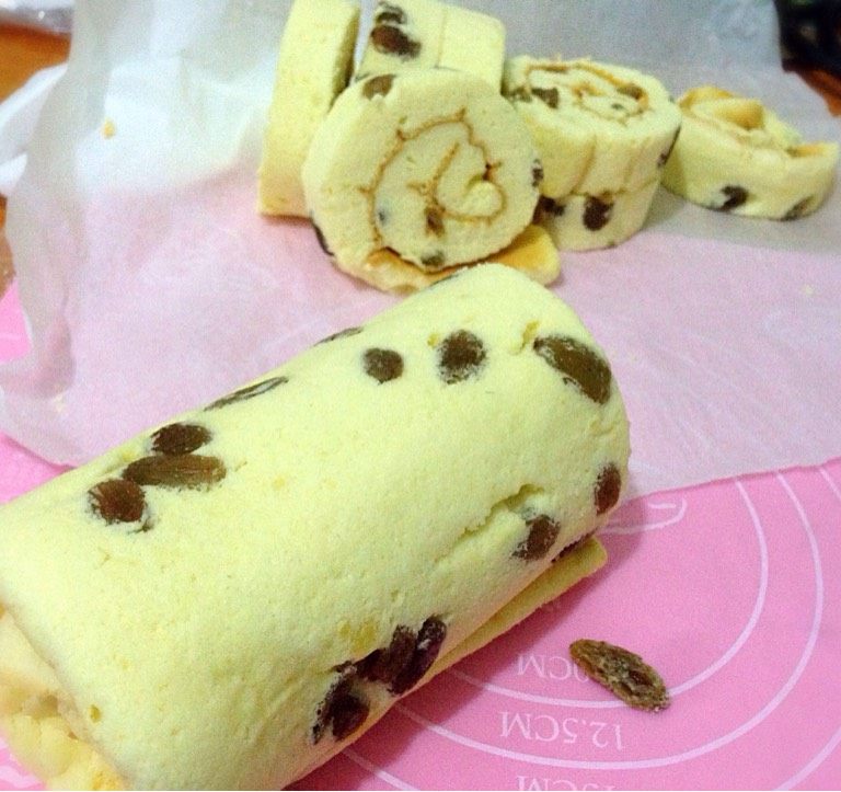 葡萄干蛋糕,出来倒扣趁热撕掉油纸,用一张新的油纸在翻面,抹上果酱或者奶油,利用擀面杖卷起冷藏30分即可切块