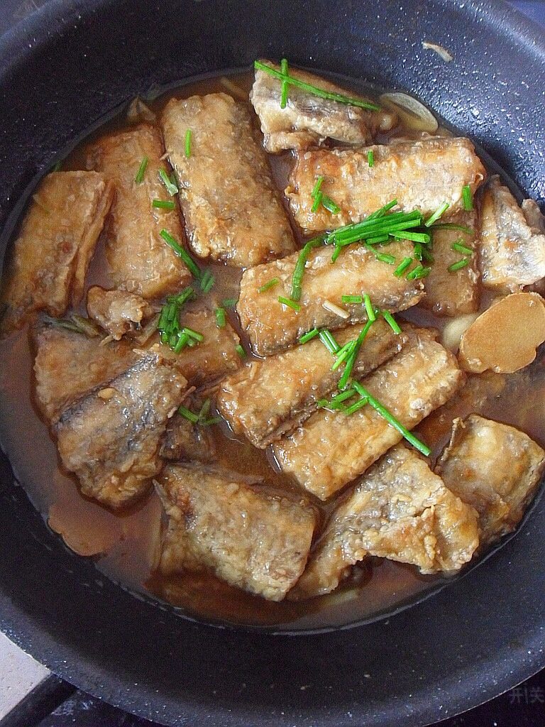 干烧带鱼,如图最后一步,锅中放入姜蒜辣椒爆香后再放入炸好的带鱼进行翻炒,翻炒时中火,此时再放入<a style='color:red;display:inline-block;' href='/shicai/ 692'>酱油</a>和两小勺的水后再次翻炒,两分中后出锅即可