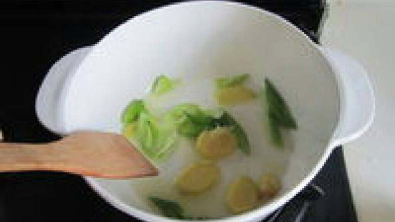 韩式泡菜豆腐锅,先倒入一点油,烧热后下入蒜 末、姜片、葱花炒香。