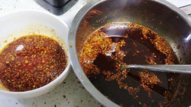 麻辣口水鸡,准备红油辣椒:菜籽油烧开后装入盆中,晾冷几分钟后倒入辣椒面,搅拌均匀即可。