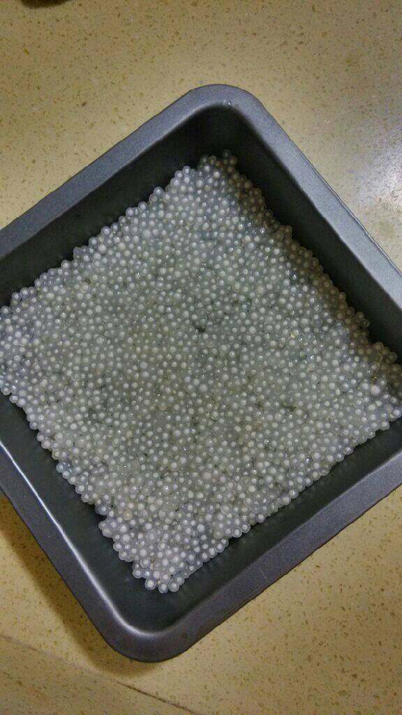 椰汁草莓西米糕,. 西米放入开水中煮熟（大约15分钟），关火焖5分钟，将煮熟的西米捞出放入清水中浸泡10分钟捞出控干水份 。西米放入容器中，加入一勺白砂糖搅拌均匀，平铺在容器底部 。