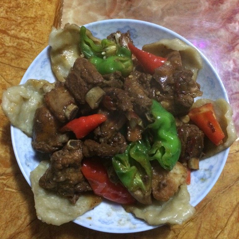 地锅排骨,如图待饼熟汤汁收差不多时将饼盛出铺入盘底，青红椒块下排骨中，加少许味精调味盛入铺好饼的盘中即可