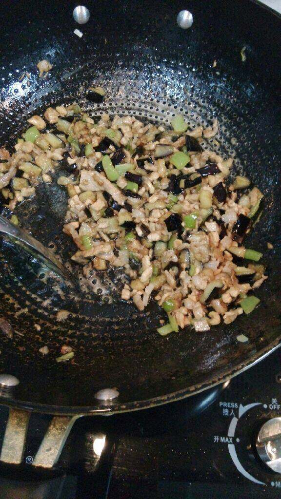 肉末茄丁面,当肉8分熟时,加入炸好的茄丁,尖椒丁翻炒,加入盐翻炒至熟即可,放在面上拌吃
