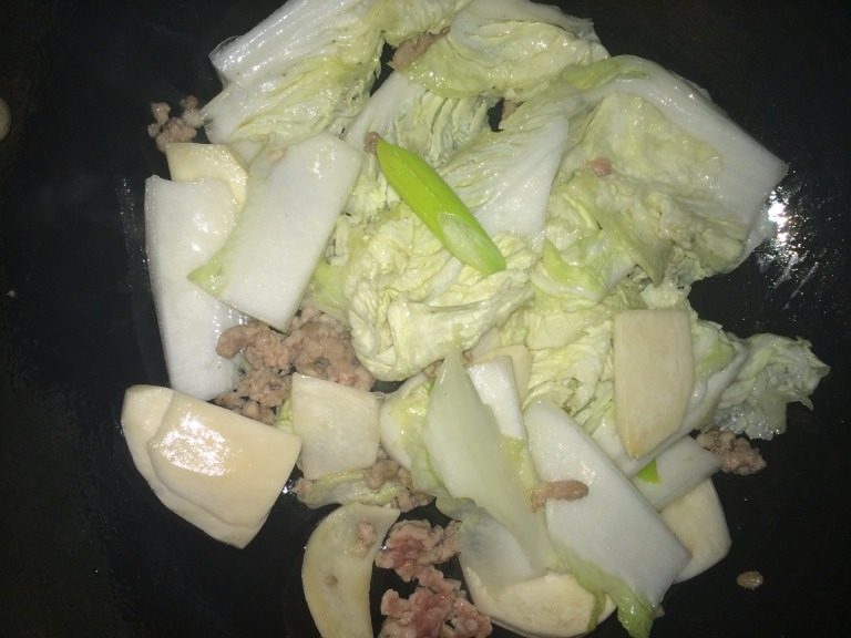辣白菜豆腐锅,少许油烧热,放肉泥炒香,放入白菜炒段生。