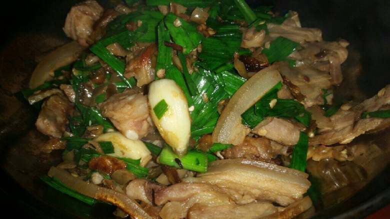 干锅白椒咸肉,放入沥干的白辣椒,翻炒,然后加入蒜叶继续翻炒。