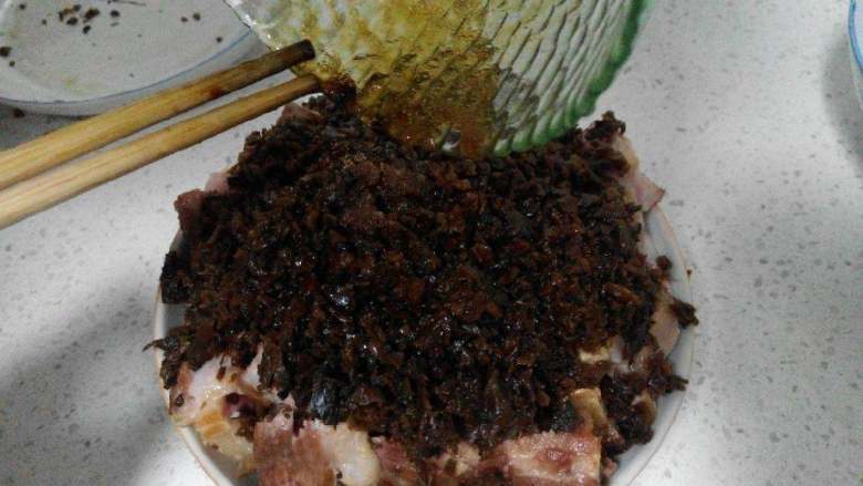 一品扣肉,把<a style='color:red;display:inline-block;' href='/shicai/ 743'>芽菜</a>码在肉上后,倒上调好的汁