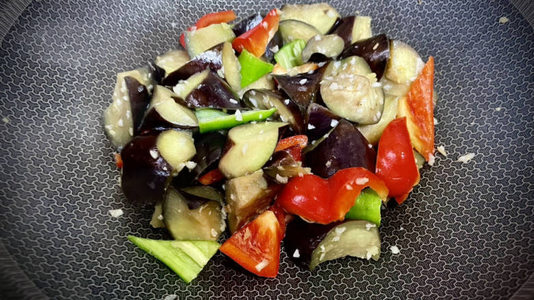 红烧茄子🍆,清洗炒锅擦干,锅烧热放一点油再放姜蓉蒜蓉彩椒翻炒几下发出香味。