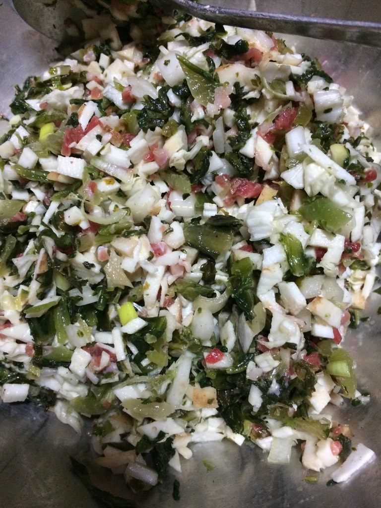 冬季养生之蒸菜饼,如图将芋头咸菜切碎拌入少量牛肉粒,打入鸡蛋,加少许胡椒粉,加入清洗干净的芹菜叶拌匀,撒入玉米面粉,搅拌均匀
