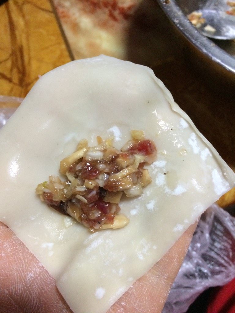 瘦肉香菇馄饨,如图取一张<a style='color:red;display:inline-block;' href='/shicai/ 4453'>馄饨皮</a>，将馅儿放入皮中间，围着馅儿抹半圈水
