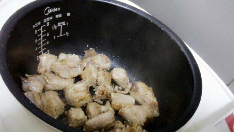 排骨焖饭,锅烧热后倒入适量食用油或猪油,放入几颗<a style='color:red;display:inline-block;' href='/shicai/ 866'>冰糖</a>炒至融化,加入排骨翻炒至排骨微黄。
