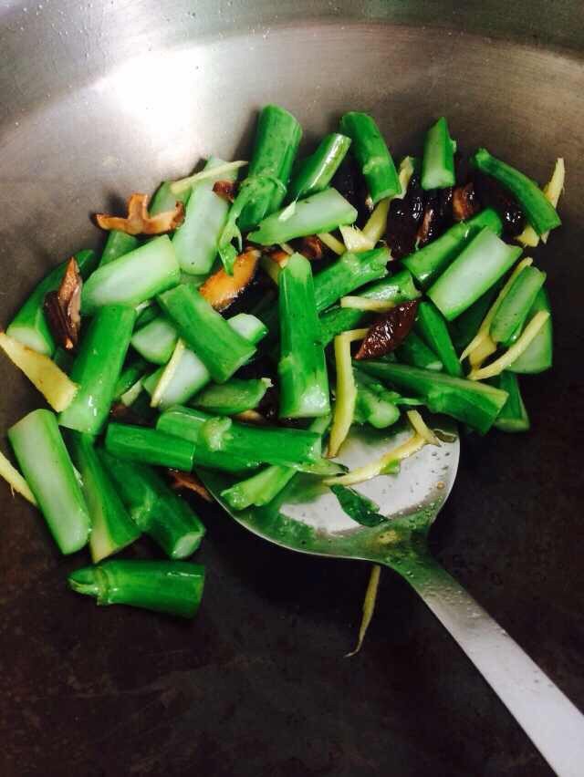 姜丝香菇炒芥蓝,锅热油，下香菇和姜丝爆香后，把芥蓝骨先下去炒