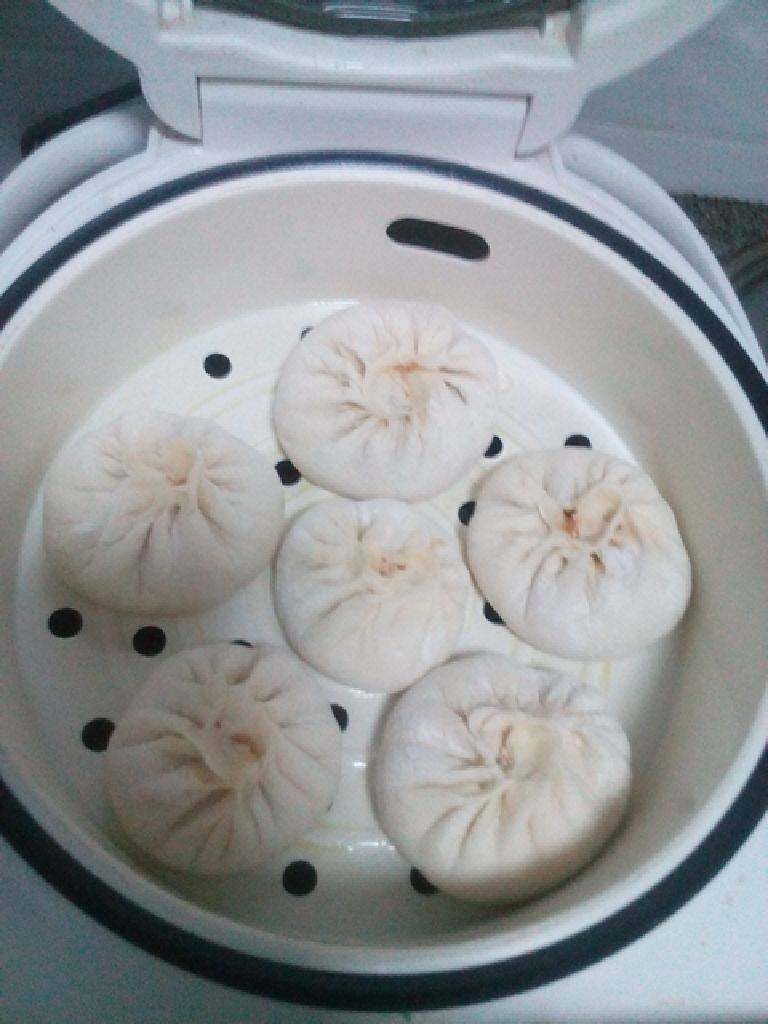 肉馅包子,锅中放入温水,将包好的包子放在屉上。进行二次发酵。
