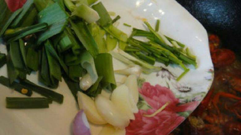 【麻辣小龙虾】,再放入剩下的青蒜,香葱和蒜片等炒匀。