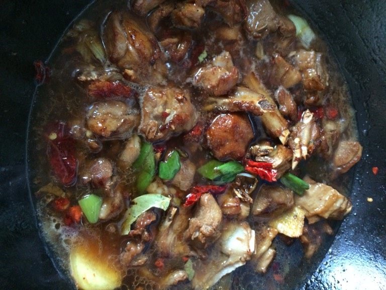 红烧小羊排,如图添入500毫升左右的开水,加少许白胡椒粉,滴一两滴香醋加盖中小火炖制二十分钟